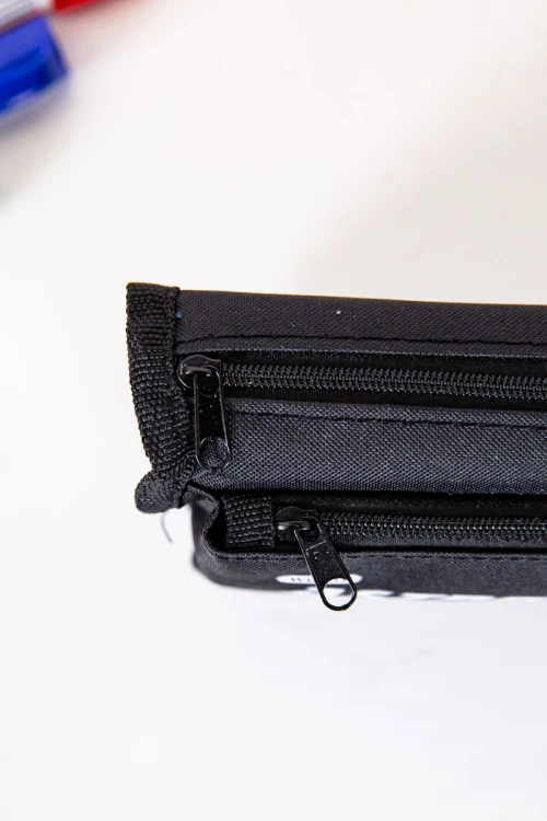 مقلمة مدرسية ولادي لون أسود مزينة بكتابات و رسومات كرتونية من الأمام و بجيوب متعددة