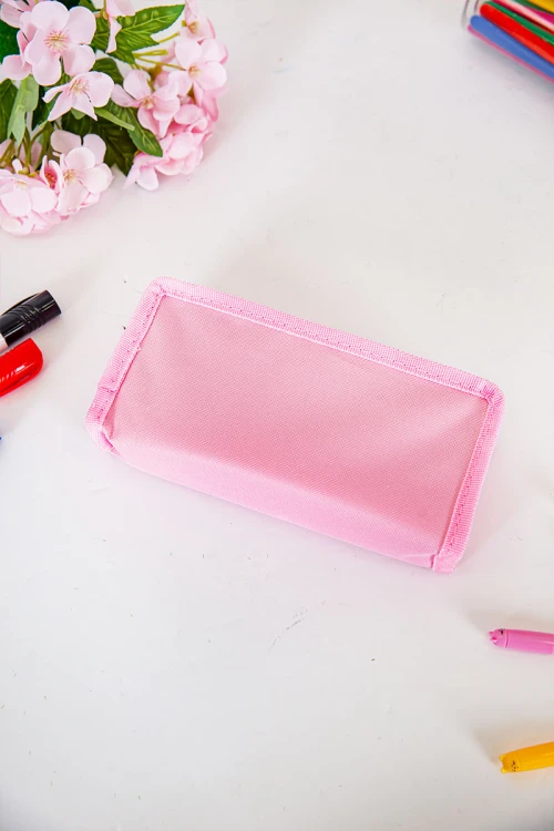 مقلمة مدرسية بناتي لون وردي مزينة بكتابات و رسومات كرتونية من الأمام و بجيوب متعددة