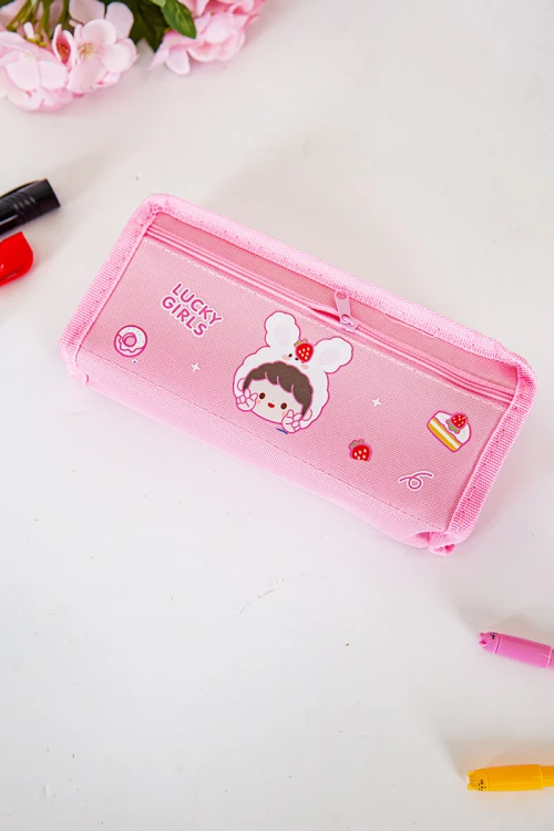 مقلمة مدرسية بناتي لون وردي مزينة بكتابات و رسومات كرتونية من الأمام و بجيوب متعددة