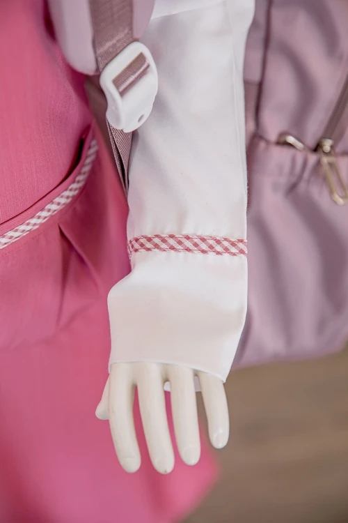 مريول بناتي مدرسي لون وردي مع قميص أبيض متصل بياقة مطوية و جيوب من الأمام و سحاب و رباط في الخلف