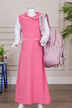 مريول بناتي مدرسي لون وردي مع قميص أبيض متصل بياقة مطوية و جيوب من الأمام و سحاب و رباط في الخلف 