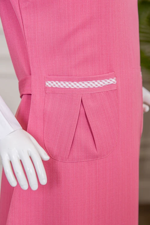 مريول بناتي مدرسي لون وردي مع قميص أبيض متصل بياقة مطوية و جيوب من الأمام و سحاب و رباط في الخلف