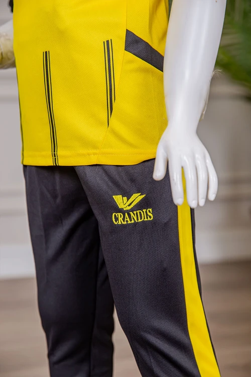 طقم ولادي رياضي قطعتين تيشيرت لون أصفر مقلم باللون الأسود و بنطلون طويل لون أسود مخطط باللون الأصفر من الجانبين و بزم من الأسفل