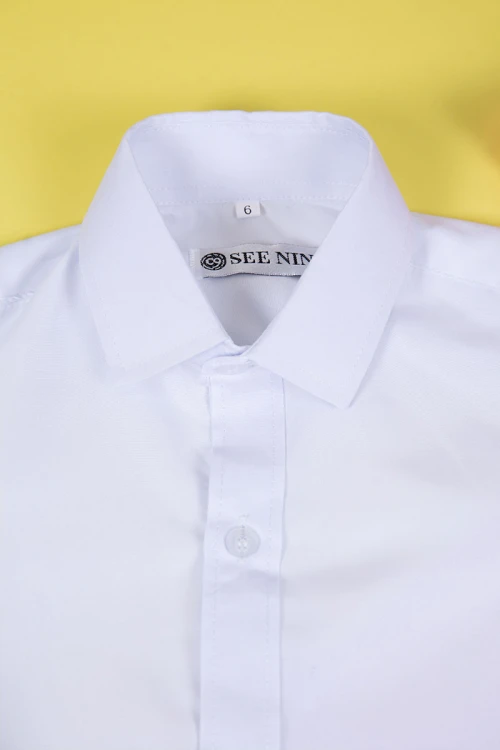 قميص مدرسي لون أبيض بياقة مطوية و بأزرار من الأمام و الأكمام