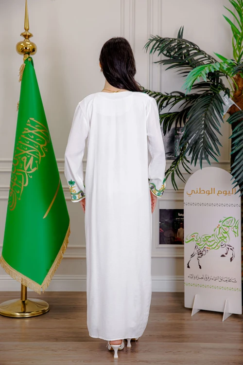 جلابية نسائية لليوم الوطني لون أبيض مزينة بتطريز شعار المملكة العربية السعودية سيفين و نخلة و بياقة مربعة