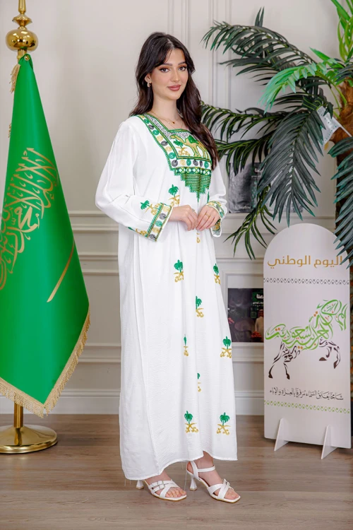 جلابية نسائية لليوم الوطني لون أبيض مزينة بتطريز شعار المملكة العربية السعودية سيفين و نخلة و بياقة مربعة