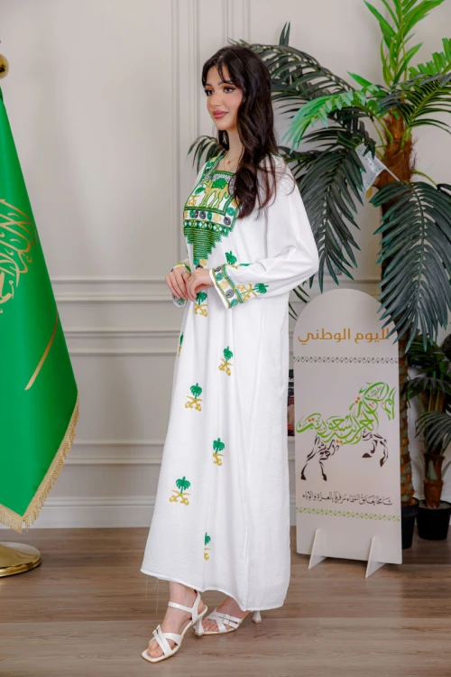 جلابية نسائية لليوم الوطني لون أبيض مزينة بتطريز شعار المملكة العربية السعودية سيفين و نخلة و بياقة مربعة