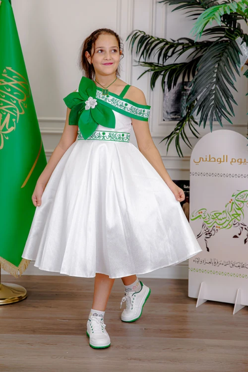 فستان بناتي لليوم الوطني لون أبيض مزين بوردة خضراء و كتابات مطرزة