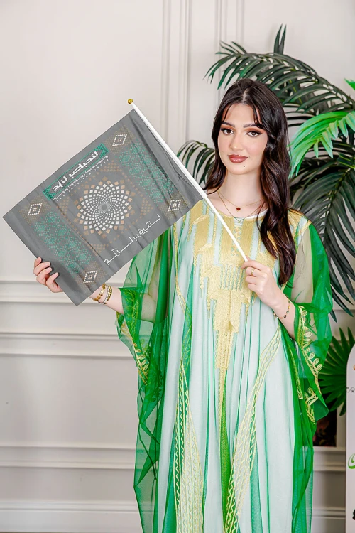 علم لليوم الوطني بشعار عزنا بطبعنا