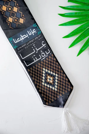 وشاح لون أسود لليوم الوطني بشعار عزنا بطبعنا