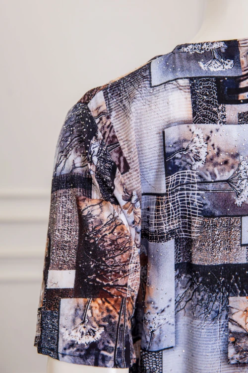 قميص نسائي طويل مزين برسومات و أشكال ملونة بفصوص ياقة دائرية بأزرار من الأمام و أكمام قصيرة