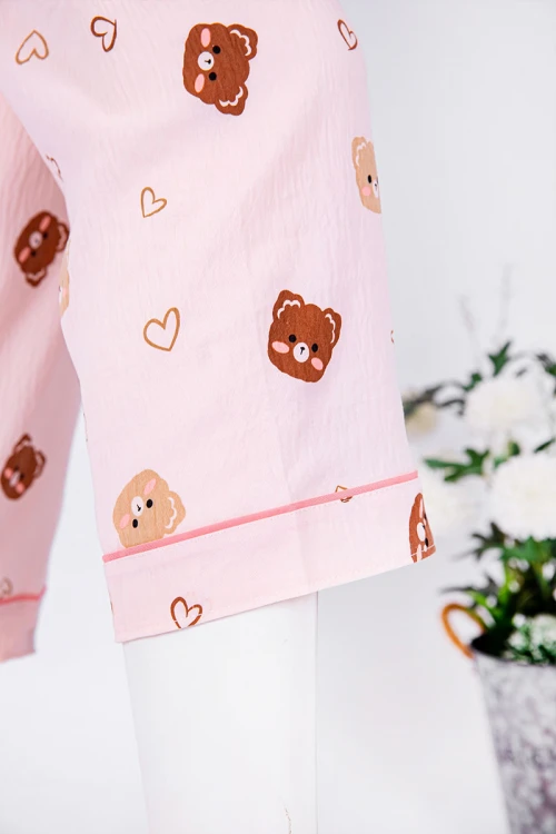 بجامة نسائية قطعتين لون خربزي مزينة برسومات بلوزة بياقة مطوية و جيب و أزرار من الأمام بأكمام طويلة مع بنطلون طويل