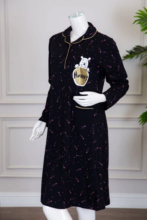 قميص نسائي شتوي ميدي لون أسود مزين بنجوم وردية و بكتابات رسومات و جيب من الأمام ياقة مطوية بأزرار و بأكمام طويلة