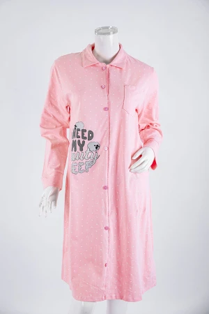 قميص نسائي شتوي ميدي لون خربزي فاتح منقط باللون الأبيض مزين برسومات و كتابات ياقة مطوية بأزرار و أكمام طويلة 