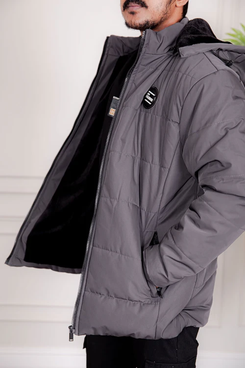 جاكيت رجالي شتوي منفوخ لون رصاصي بقبعة رأس منفصلة قابلة للتركيب و أكمام طويلة بجيوب وسحاب من الأمام