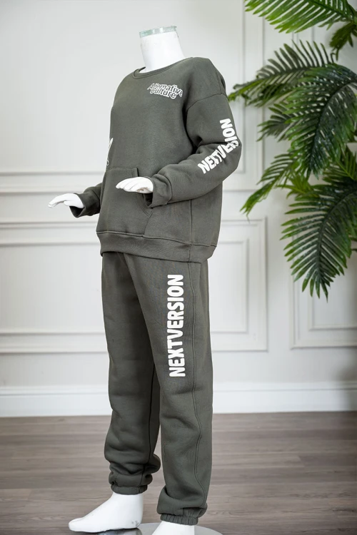 طقم قطعتين ولادي شتوي لون زيتي مزين بكتابات من الأمام و الخلف بلوزة ياقة دائرية بجيوب و أكمام طويلة و بنطلون طويل