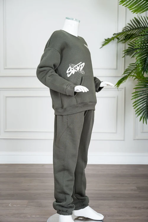 طقم قطعتين ولادي شتوي لون زيتي مزين بكتابات من الأمام و الخلف بلوزة ياقة دائرية بجيوب و أكمام طويلة و بنطلون طويل