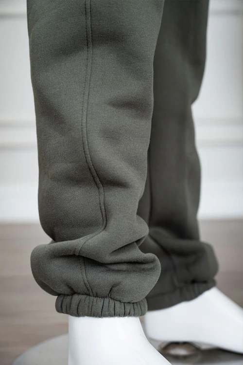 طقم قطعتين ولادي شتوي لون زيتي مزين بكتابات من الأمام و الخلف بلوزة ياقة دائرية بجيوب و أكمام طويلة و بنطلون طويل