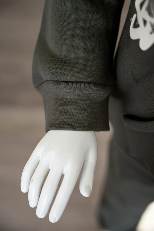 طقم قطعتين ولادي شتوي لون زيتي مزين بكتابات من الأمام و الخلف بلوزة ياقة دائرية بجيوب و أكمام طويلة و بنطلون طويل