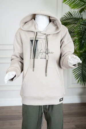 طقم قطعتين ولادي شتوي بلوزة لون بيج مزينة بكتابات من الأمام بقبعة متصلة برباط و بجيوب و أكمام طويلة و بنطلون طويل لون زيتي برباط في الخصر 