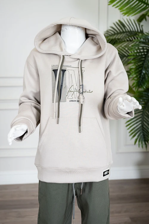 طقم قطعتين ولادي شتوي بلوزة لون بيج مزينة بكتابات من الأمام بقبعة متصلة برباط و بجيوب و أكمام طويلة و بنطلون طويل لون زيتي برباط في الخصر