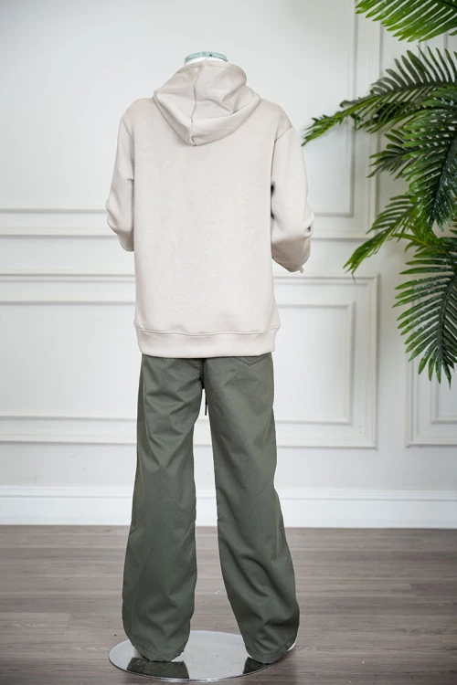 طقم قطعتين ولادي شتوي بلوزة لون بيج مزينة بكتابات من الأمام بقبعة متصلة برباط و بجيوب و أكمام طويلة و بنطلون طويل لون زيتي برباط في الخصر