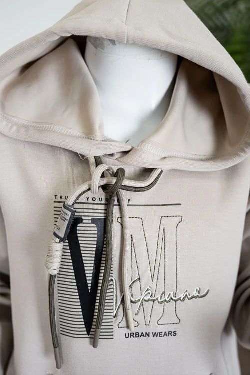 طقم قطعتين ولادي شتوي بلوزة لون بيج مزينة بكتابات من الأمام بقبعة متصلة برباط و بجيوب و أكمام طويلة و بنطلون طويل لون زيتي برباط في الخصر