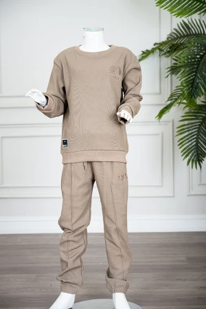 طقم قطعتين ولادي شتوي لون بيج غامق مزين بكتابات من الأمام بلوزة ياقة دائرية بأكمام طويلة و بنطلون طويل برباط في الخصر 
