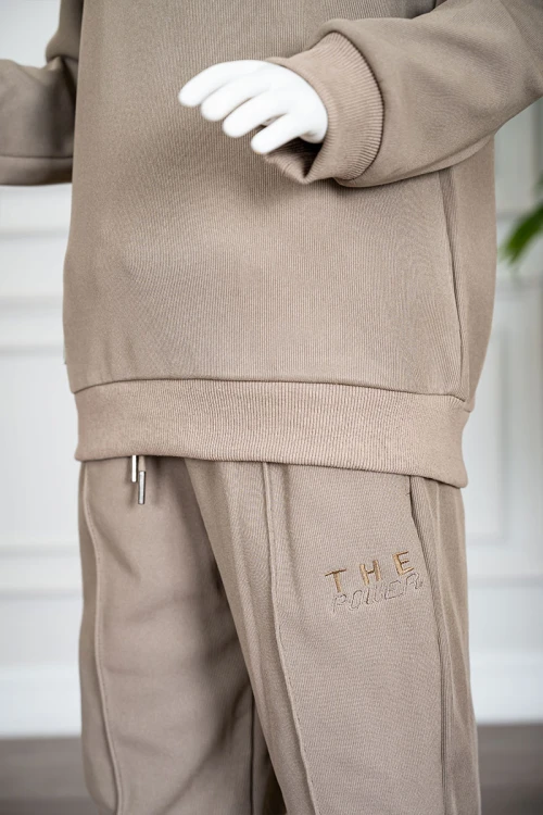 طقم قطعتين ولادي شتوي لون بيج غامق مزين بكتابات من الأمام بلوزة ياقة دائرية بأكمام طويلة و بنطلون طويل برباط في الخصر