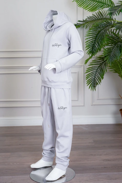 طقم بناتي شتوي قطعتين لون رمادي فاتح هودي بقبعة متصلة برباط و بجيوب الكنغر و أكمام طويلة مع بنطلون طويل برباط في الخصر و جيوب من الجانبين