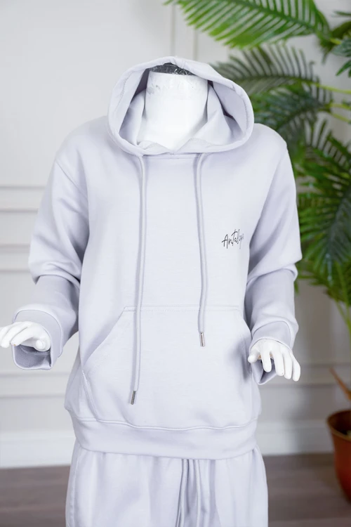 طقم بناتي شتوي قطعتين لون رمادي فاتح هودي بقبعة متصلة برباط و بجيوب الكنغر و أكمام طويلة مع بنطلون طويل برباط في الخصر و جيوب من الجانبين