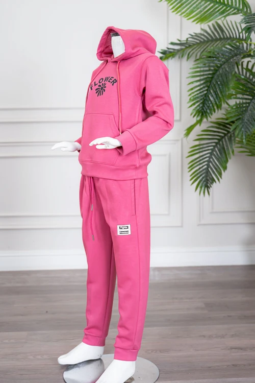 طقم بناتي شتوي قطعتين لون وردي هودي بقبعة متصلة برباط و بجيوب الكنغر و أكمام طويلة مزين بكتابات من الأمام  مع بنطلون طويل برباط في الخصر و جيوب من الجانبين