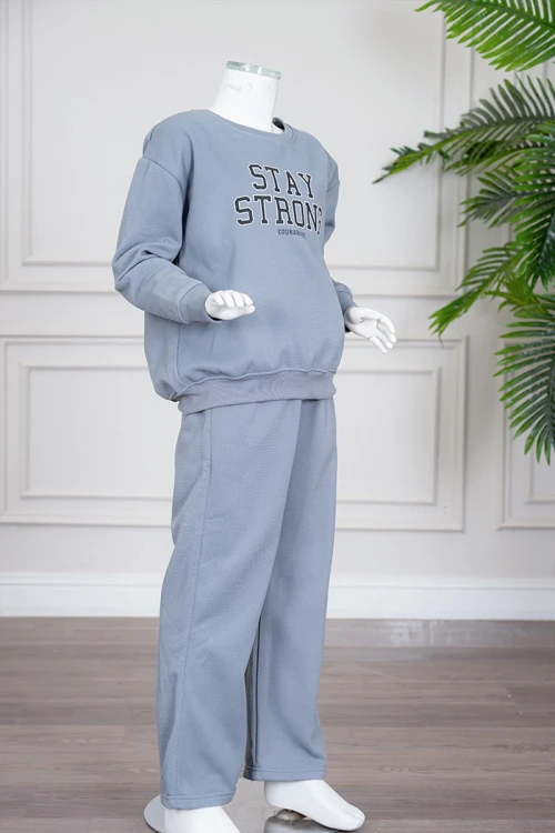 طقم بناتي شتوي قطعتين لون أزرق فاتح بلوزة بياقة دائرية و أكمام طويلة مع بنطلون طويل برباط في الخصر و جيوب من الجانبين