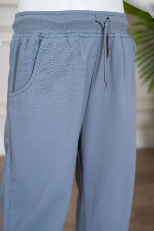 طقم بناتي شتوي قطعتين لون أزرق فاتح بلوزة بياقة دائرية و أكمام طويلة مع بنطلون طويل برباط في الخصر و جيوب من الجانبين