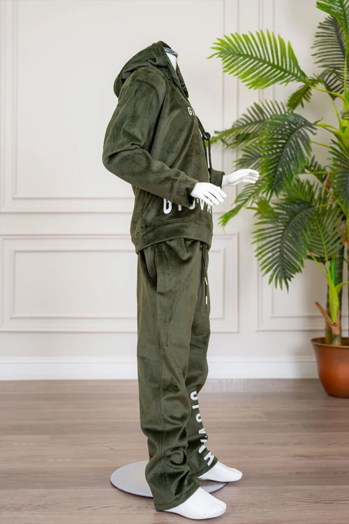 طقم بناتي شتوي قطعتين لون زيتي هودي بقبعة متصلة برباط و أكمام طويلة مزين بكتابات باللون الأبيض مع بنطلون طويل برباط في الخصر و جيوب من الجانبين