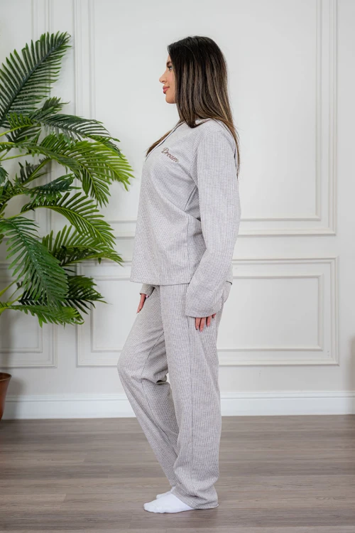 بيجاما نسائية قطعتين لون بيج مزينة بكتابات من الأمام ياقة دائرية بأزرار و بأكمام طويلة مع بنطلون طويل برباط في الخصر