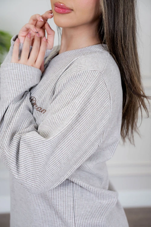 بيجاما نسائية قطعتين لون بيج مزينة بكتابات من الأمام ياقة دائرية بأزرار و بأكمام طويلة مع بنطلون طويل برباط في الخصر