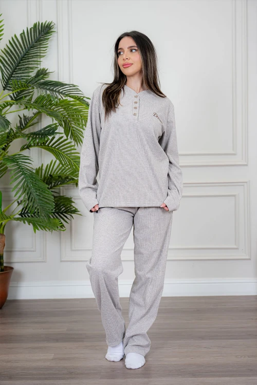 بيجاما نسائية قطعتين لون بيج مزينة بكتابات من الأمام ياقة دائرية بأزرار و بأكمام طويلة مع بنطلون طويل برباط في الخصر