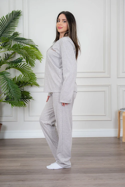 بيجاما نسائية قطعتين لون بيج مزينة بكتابات من الأمام ياقة دائرية بأزرار و بأكمام طويلة مع بنطلون طويل برباط في الخصر