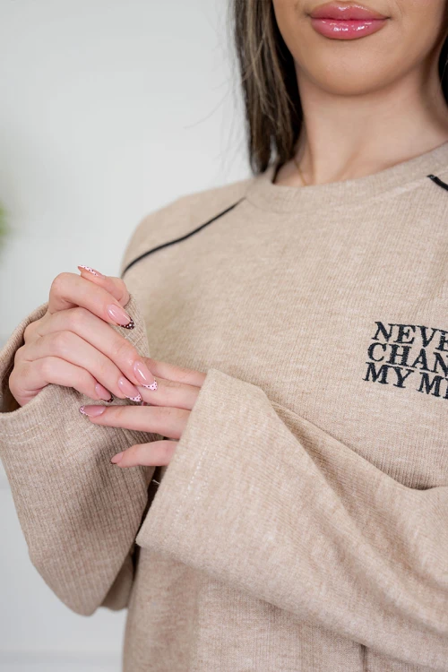 بيجاما نسائية قطعتين لون بيج مزينة بكتابات وخطوط باللون الأسود من الأمام ياقة دائرية و بأكمام طويلة مع بنطلون طويل