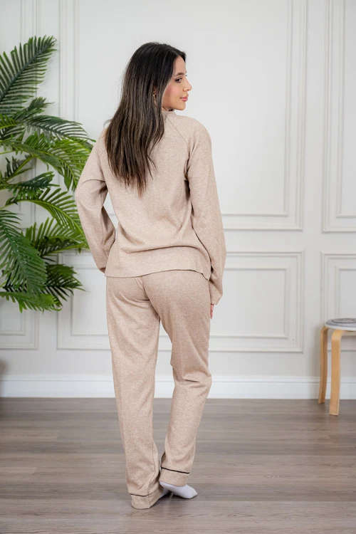 بيجاما نسائية قطعتين لون بيج مزينة بكتابات وخطوط باللون الأسود من الأمام ياقة دائرية و بأكمام طويلة مع بنطلون طويل