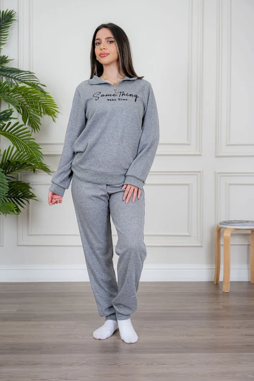 بيجاما نسائية قطعتين لون رمادي مزينة بكتابات من الأمام ياقة عالية بسحاب و بأكمام طويلة مع بنطلون طويل برباط في الخصر