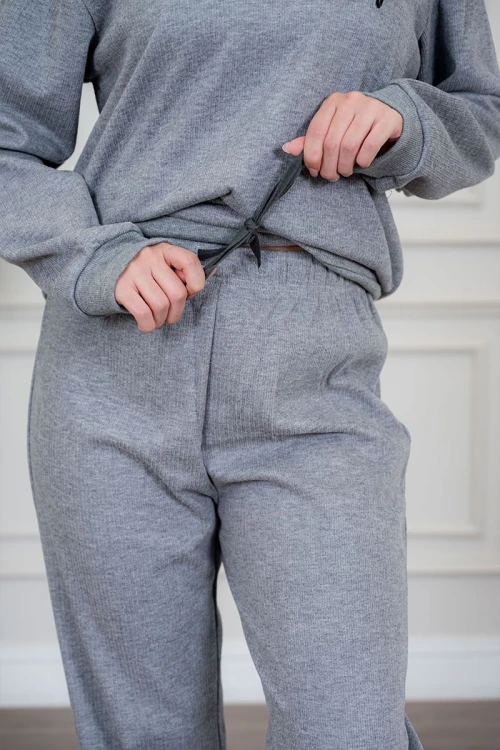 بيجاما نسائية قطعتين لون رمادي مزينة بكتابات من الأمام ياقة عالية بسحاب و بأكمام طويلة مع بنطلون طويل برباط في الخصر