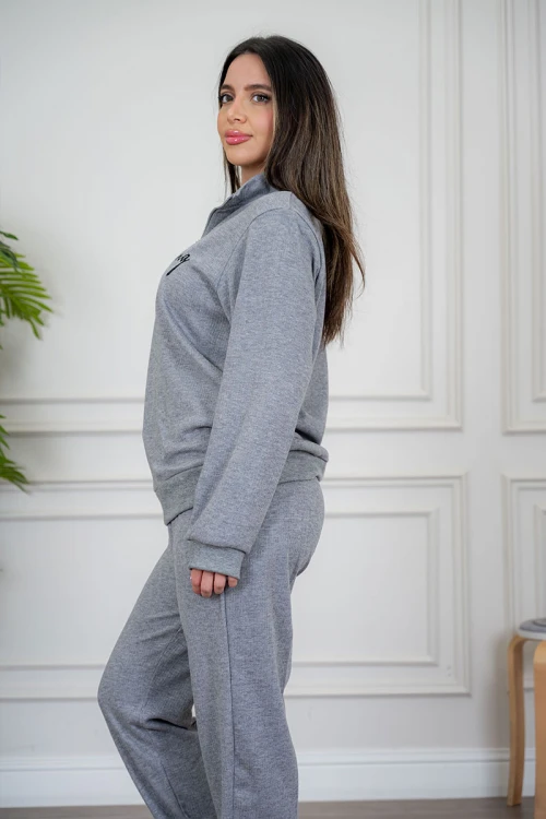 بيجاما نسائية قطعتين لون رمادي مزينة بكتابات من الأمام ياقة عالية بسحاب و بأكمام طويلة مع بنطلون طويل برباط في الخصر