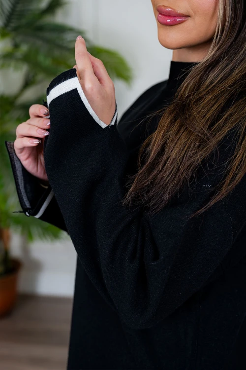 طقم تريكو نسائي شتوي قطعتين لون أسود مزين من الأطراف باللون الأبيض ياقة عالية مع بنطلون طويل