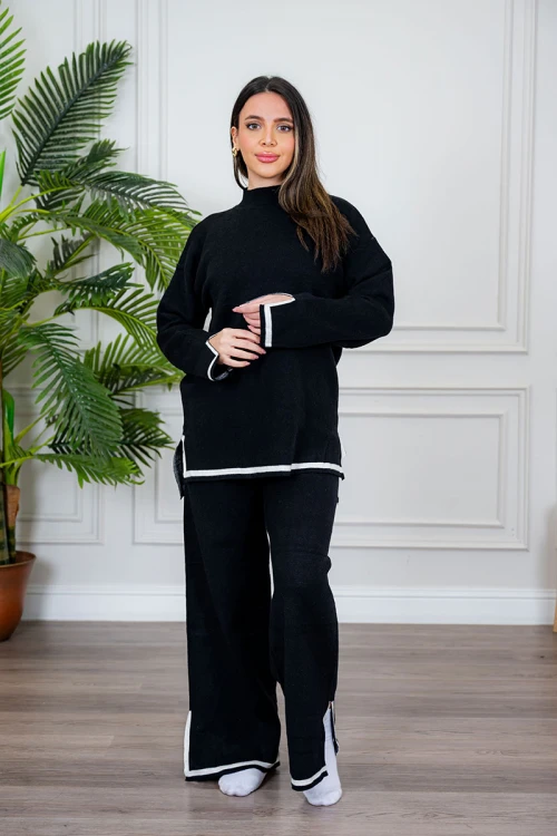 طقم تريكو نسائي شتوي قطعتين لون أسود مزين من الأطراف باللون الأبيض ياقة عالية مع بنطلون طويل