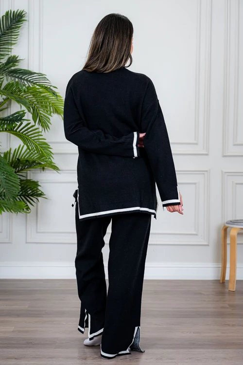 طقم تريكو نسائي شتوي قطعتين لون أسود مزين من الأطراف باللون الأبيض ياقة عالية مع بنطلون طويل