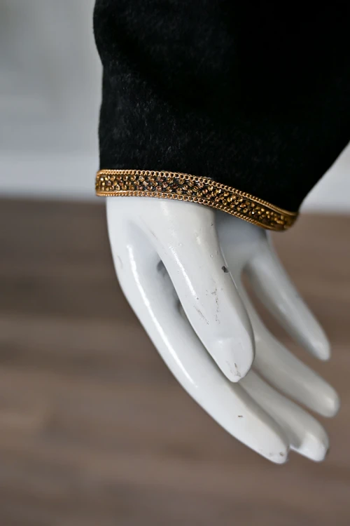 جلابية نسائية طويلة صوف لون أسود مزينة بكلفة باللون الذهبي في الياقة من الأمام و الأكمام