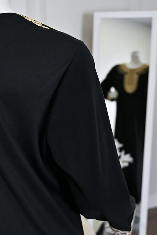 جلابية نسائية طويلة لون أسود مزينة بتطريز باللون الذهبي في الياقة من الأمام و الأكمام