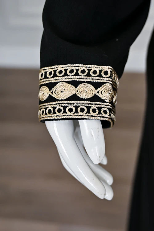 جلابية نسائية طويلة لون أسود مزينة بتطريز باللون الذهبي في الياقة من الأمام و الأكمام